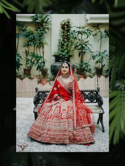 This portrait uses a creative leafy border to frame the bride on the bench, adding an artistic and natural element to a classic wedding photo.