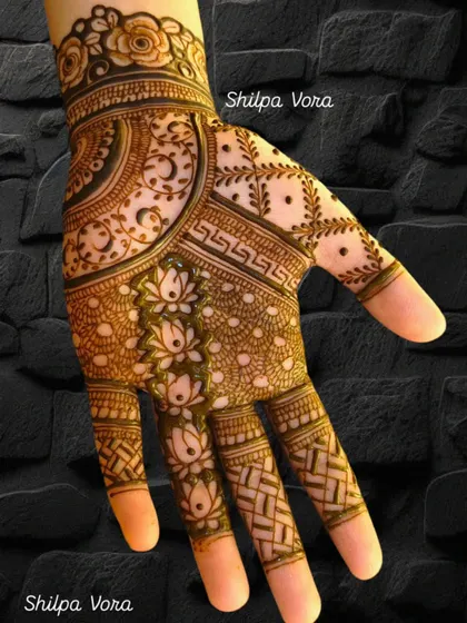 A modern take on a floral design, with lotus patterns on the fingers and a mix of geometric and vine patterns on the palm.