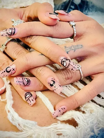 For those who love a bit of magic, we designed this custom set with mystical and celestial symbols. Each nail tells a story with intricate line work on a sheer, natural base.