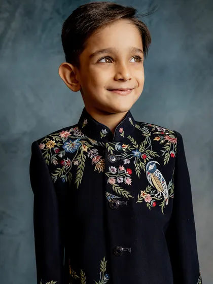 A portrait of our young model wearing the timeless embroidered Indo-western piece. His confident smile shows he feels just as good as he looks.