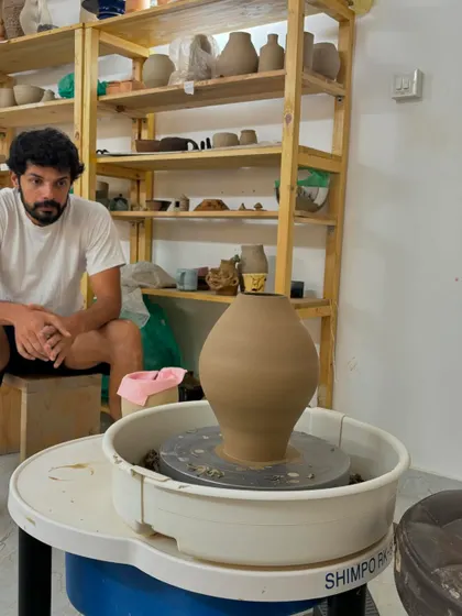 Another shot of Pradyumna with his work. He enjoys exploring new techniques in both wheel throwing and hand-building, and his dedication is inspiring.