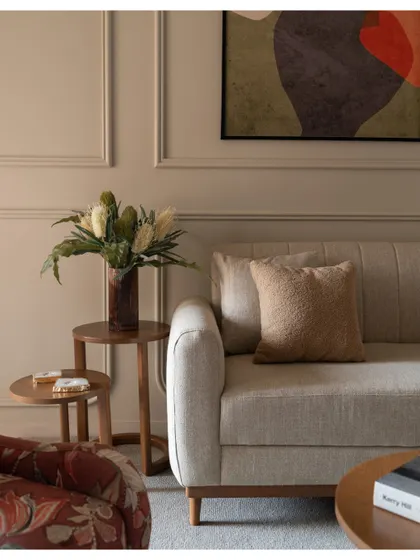 A detail shot showing the clean lines of the sofa and the elegant wall molding that adds a touch of classic character.