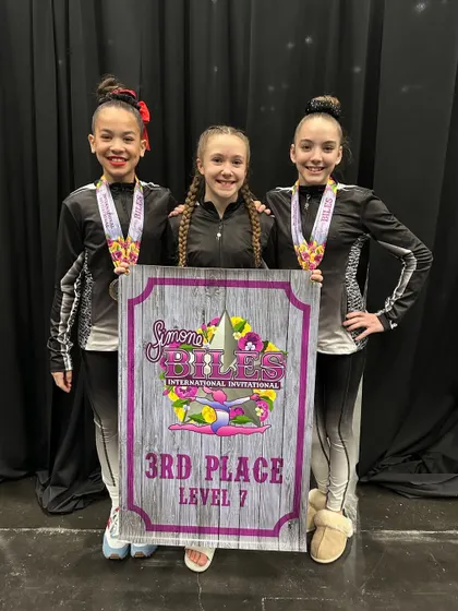 Our Level 7 team showing off their 3rd place banner at the prestigious Simone Biles Invitational. Competing at this level is an incredible experience for our athletes.