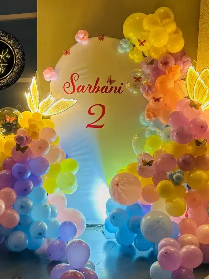A colorful butterfly theme for Sarbani's 2nd birthday, with light-up butterfly props and a multi-colored balloon arch.