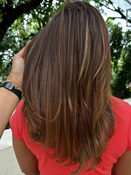 The back view of this party-ready hair, showing off the straight, sleek style and fresh highlights.