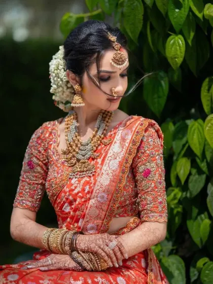 A side profile of the bride, highlighting the beautiful floral arrangement in her hair and the soft, blended eyeshadow.
