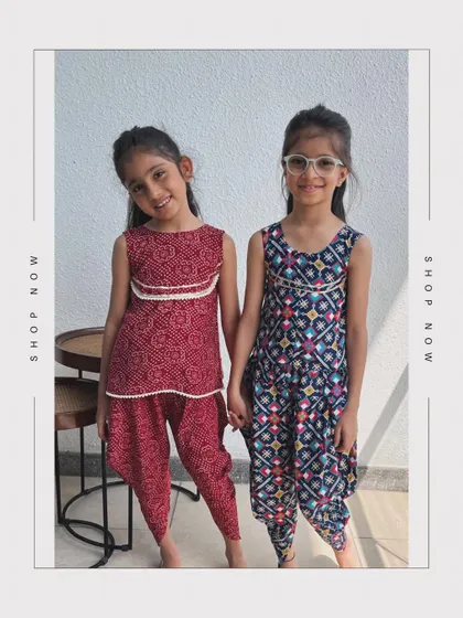 Two friends showing off their traditional dhoti-kurta sets. One is a deep red bandhani print, and the other is a multi-color patola print.