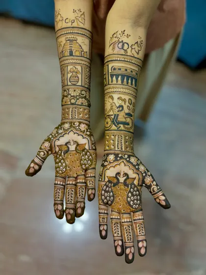 Another shot of the personalized engagement mehendi, showing the fine details of the peacock and story elements.