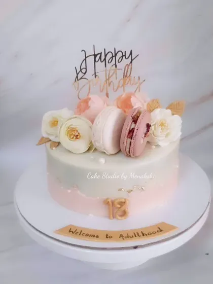 A pretty 18th birthday cake to welcome adulthood. This no-fondant design is decorated with macarons and flowers, making it a chic and sophisticated choice.