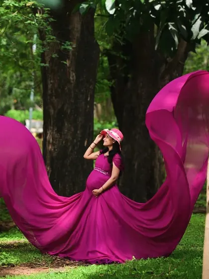This magenta trail gown is a favorite for maternity shoots. The vibrant color and the dramatic flowing fabric create breathtaking photos, especially in outdoor settings.