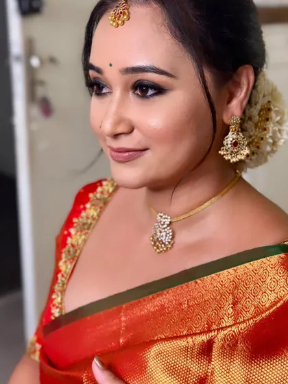 A side profile of Chaitra, showing the clean lines of her makeup and the elegance of her traditional hairstyle.