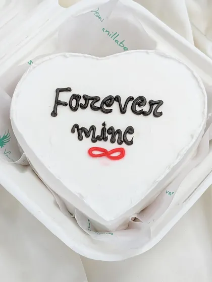 A heart-shaped bento cake with a simple, bold message: "Forever mine." The infinity symbol adds a modern touch to this romantic and personal dessert.