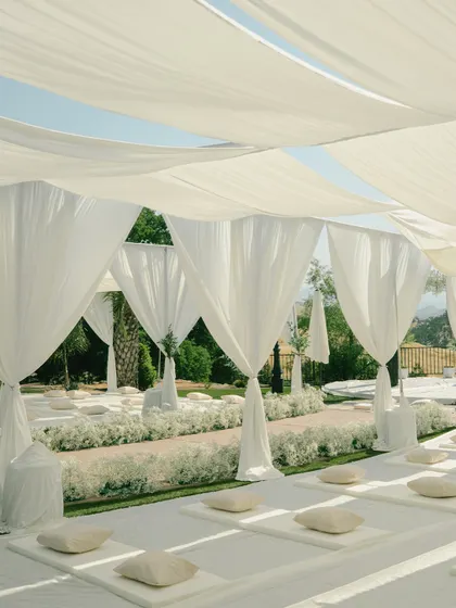 The serene and elegant setup for a Sikh wedding ceremony, with flowing white drapes and clean seating arrangements, creating a peaceful and sacred space.