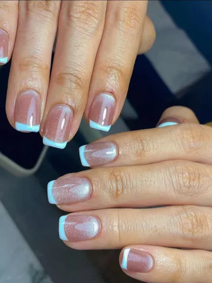 A pop of color for your French tips. This design features a soft cat-eye base with crisp, light blue tips for a fresh and modern look.