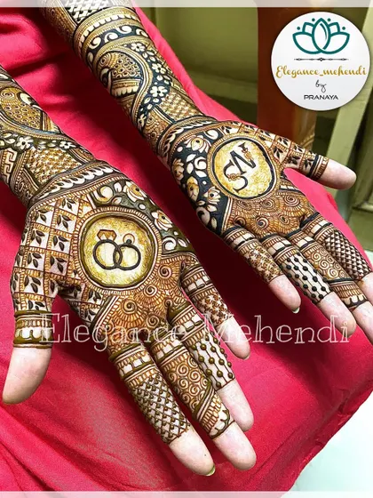 A close-up of the engagement mehendi palms, highlighting the personalized ring and initial motifs.