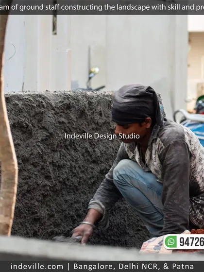 A mason applying plaster to a newly constructed planter wall, showcasing the detailed construction work my team handles.