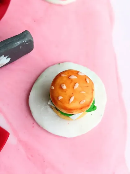 Look at this tiny, detailed burger! I sculpted this mini burger with lettuce, cheese, and a sesame seed bun for a cake celebrating a food lover.