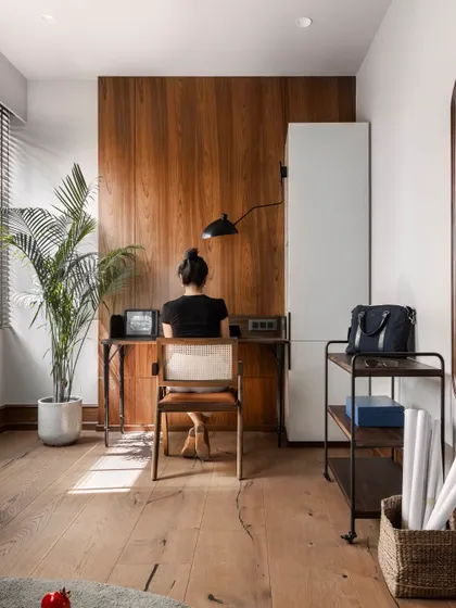 My personal cabin is a hybrid of a cozy retreat and a functional office. This view shows my workspace, with a rich wood-paneled wall, a sleek desk, and natural light, creating an environment where creativity flows effortlessly.