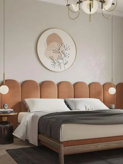 An example of an earthy, warm bedroom design. The scalloped, terracotta-colored headboard is paired with minimalist pendant lights and abstract art, creating a soft and inviting atmosphere.