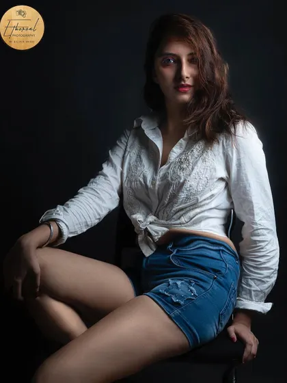 A classic studio portrait for a model's portfolio. The simple white shirt and denim shorts look is timeless, and the lighting is crafted to create a bold and confident image.