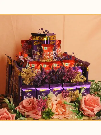 A chocolate lover's dream! This hamper is a multi-layered cake of Cadbury Dairy Milk and KitKat bars, decorated with artificial flowers. It's a fun and indulgent gift for any celebration.
