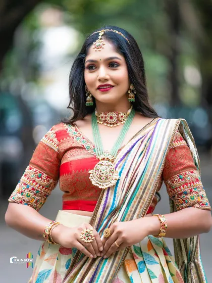 A close-up of the model in the multi-color leaf print half saree, showing the detailed embroidery on the red blouse.