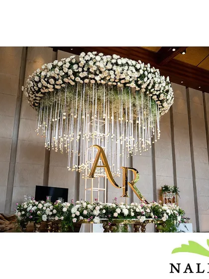 This custom floral chandelier, featuring the couple's initials "A R" in gold, served as a stunning centerpiece. This type of personalized branding is perfect for making a corporate event or launch feel unique and exclusive.