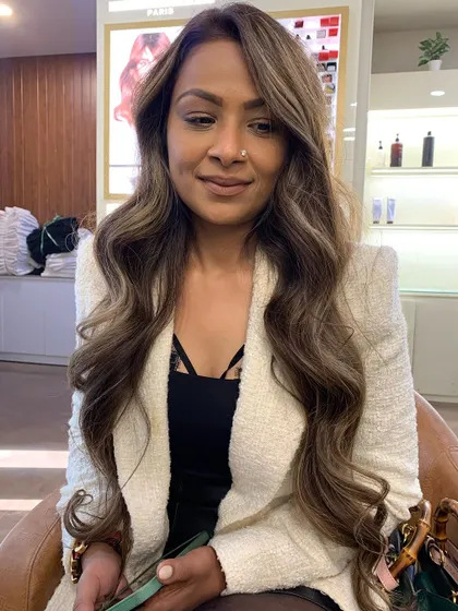 A happy client showing off her new ash brown hair color. The waves and layers perfectly showcase the multi-tonal look.