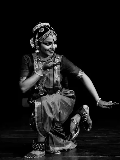 A black and white photograph of Sandhya Udupa, capturing a moment of poetic grace during her performance.