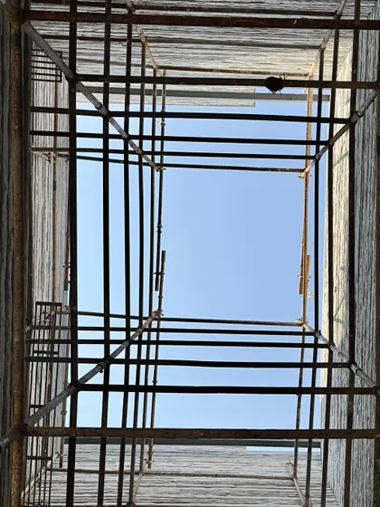 Looking up through a scaffold-filled light-well to the sky. This image captures a moment in the making, a frame for the sky that will soon be a source of light for the finished building.