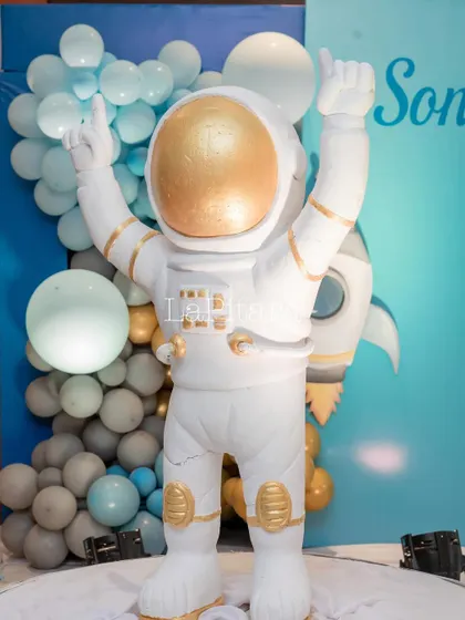 A large, life-sized astronaut statue with a golden helmet, serving as a major focal point and an impressive piece of decor.