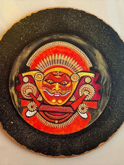 Another angle of the Theyyam plate, showing how the light catches the golden details and the textured, starry-night background.