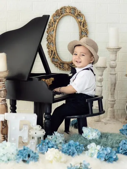 A mini maestro at his first birthday shoot. The tiny piano is one of our most loved props, perfect for a classic and charming one-year-old portrait.