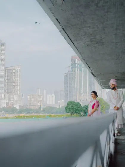 A modern couple portrait against the Mumbai city skyline. This shot captures the couple in their element, blending tradition with their urban environment.