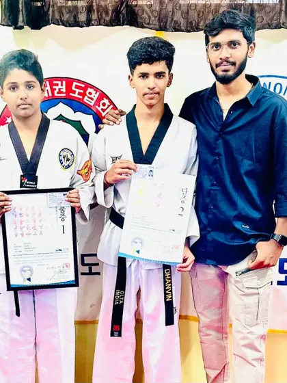 Two students proudly display their black belt certificates.