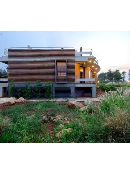 This image from a publication shows the "Breathe" house nestled in its native grass landscape, demonstrating the harmony between the built form and its environment.