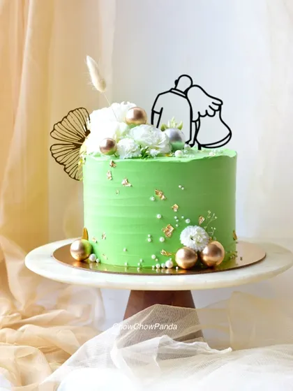 A different angle of the green anniversary cake, showing the delicate floral arrangement.