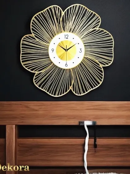 The golden leaf wall clock, shown here above a headboard, makes for a beautiful and functional piece of bedroom decor.