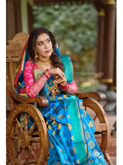 A creative shot featuring the actress on a unique wooden chair, her traditional jewellery standing out.