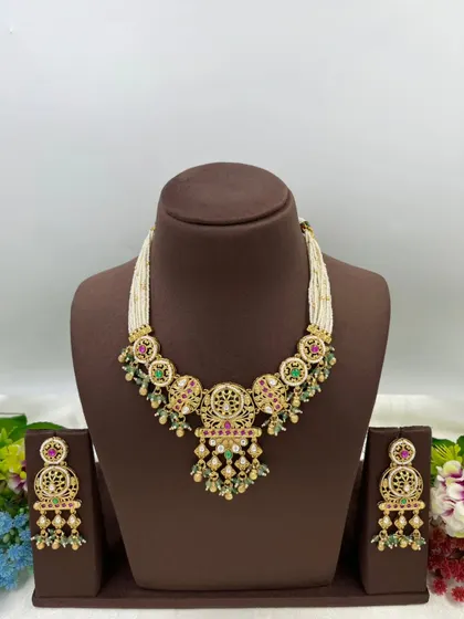 An antique-style necklace set with intricate detailing and multi-color stones, shown from different angles.