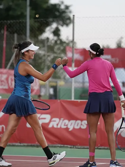 A fist bump of encouragement between partners. Teamwork and positive reinforcement are crucial elements we emphasize for doubles play.