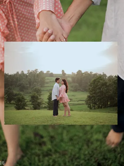 A creative shot framing the couple's embrace with their own hands, set against a backdrop of green hills.