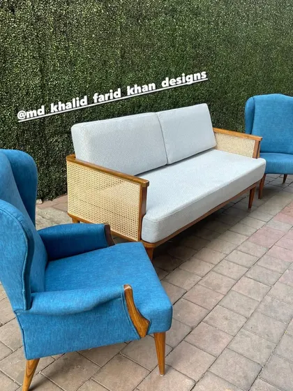 The blue wingback chairs paired with a modern cane sofa, creating an eclectic and stylish seating arrangement.