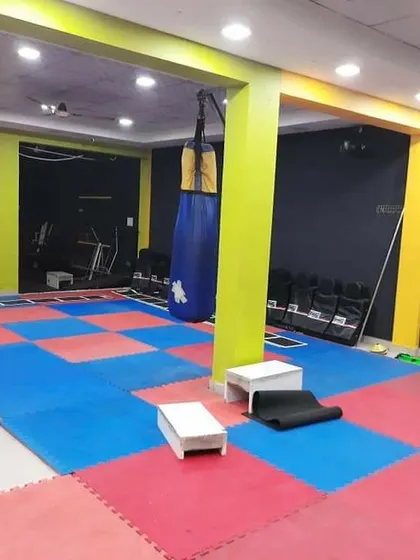 The open space in our gym, featuring a heavy bag and matted floors, is perfect for functional fitness, agility drills, and kickboxing practice.