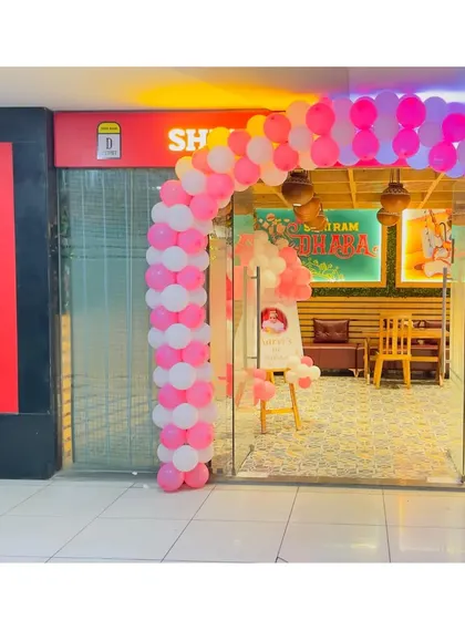 The entrance to Aarvi's party, with a pink and white balloon arch welcoming guests to the celebration at Shri Ram Dhaba.