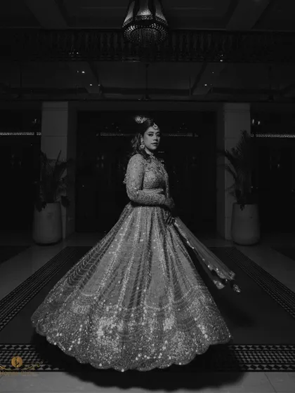 A full-length black and white portrait of the bride, her sparkling lehenga twirling around her. This shot is pure elegance and drama.