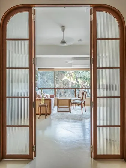 I love creating spaces that can adapt to your life. For this nutrition clinic, I designed these arched, fluted glass doors to beautifully separate the main living area from the workspace, allowing it to transform into a cozy bedroom at night.