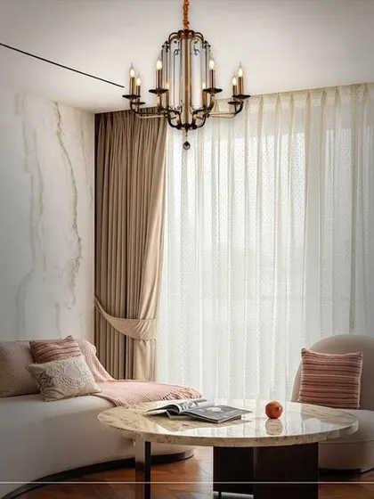 Luxury can be both grand and gentle. In this serene living room, a classic candelabra-style chandelier provides a timeless elegance. It complements the soft, neutral palette and sophisticated furnishings, creating a space that feels both luxurious and welcoming.