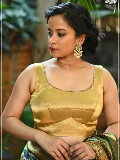 A classic sleeveless golden blouse with a scoop neckline, perfect for pairing with a rich Kanjivaram saree.