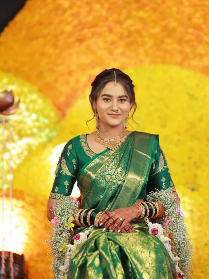A portrait of the bride against a vibrant marigold backdrop. Her simple and elegant fresh flower jewellery provides a beautiful contrast.